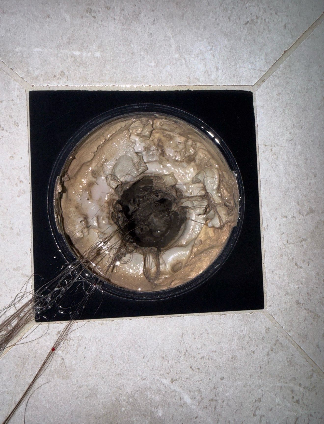 Heavily blocked shower floor drain with hair and soap scum Brunswick